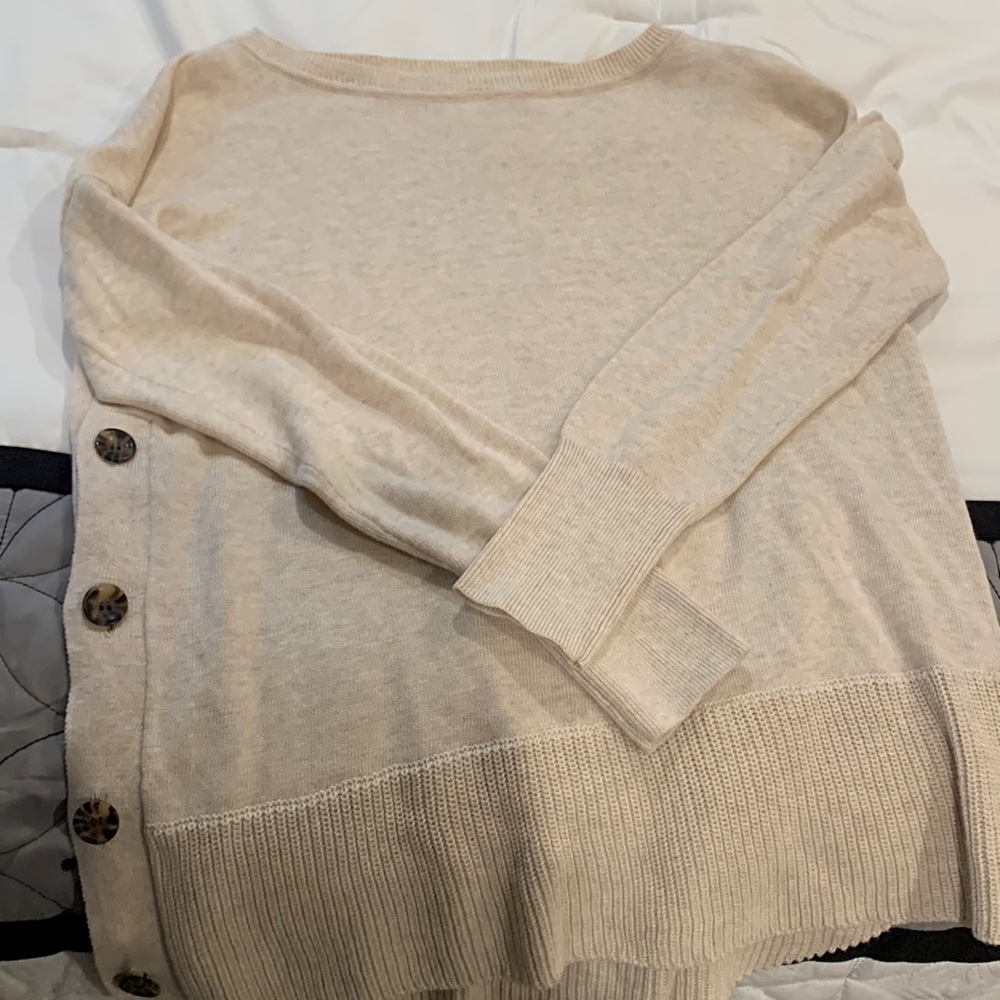 Lightweight sweater with cute side button detail. Never worn. Tag cut out.